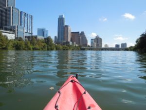 a kayak on the water with a city in the background