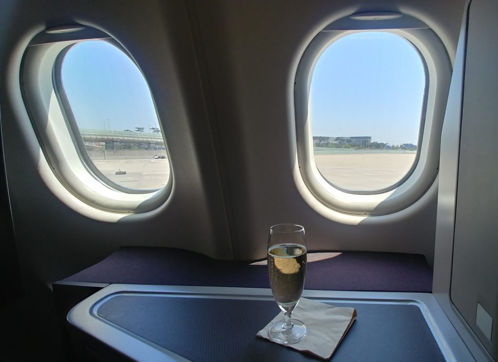 a glass of champagne on a table in an airplane
