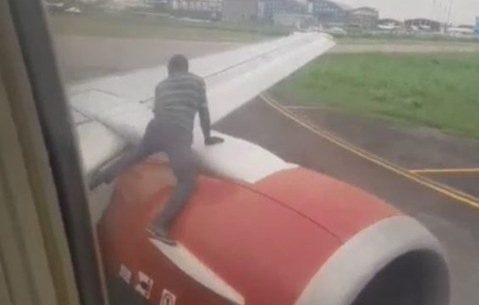 a man climbing on the wing of an airplane