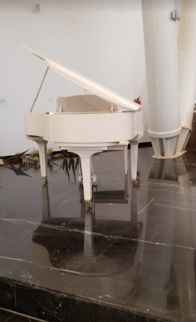 a white piano on a shiny floor