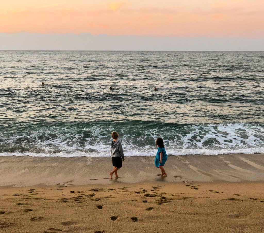 two children walking on a beach