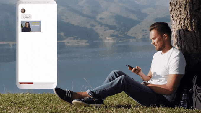 a man sitting on grass looking at his phone