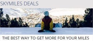 a person sitting on the snow looking at a city