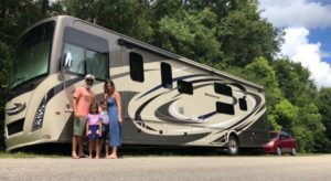 a family standing in front of a rv