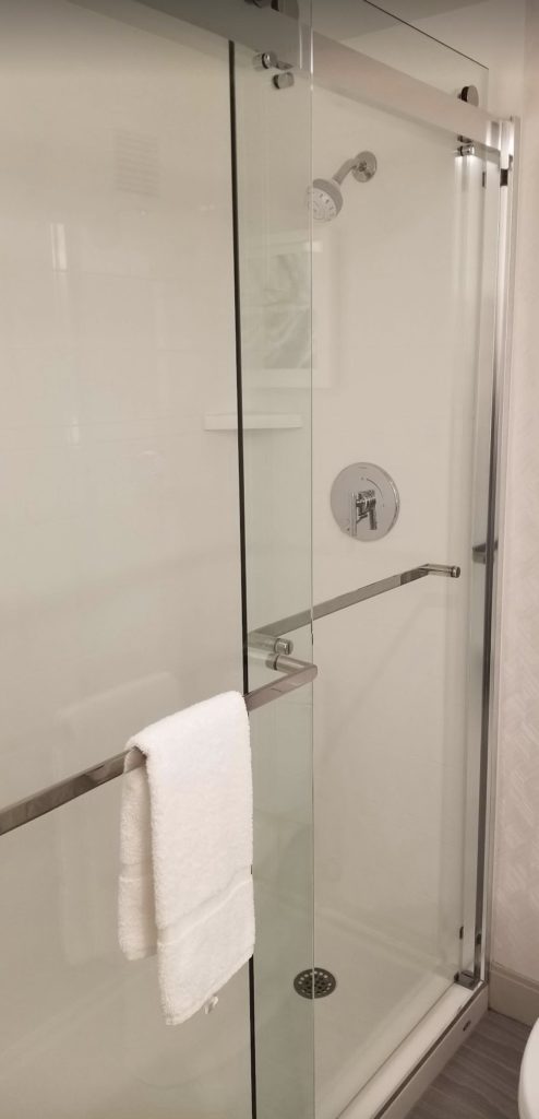 a glass shower door with a towel on a bar