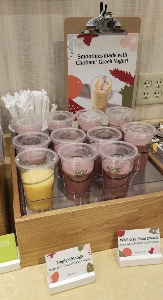 a group of plastic cups of drinks on a table