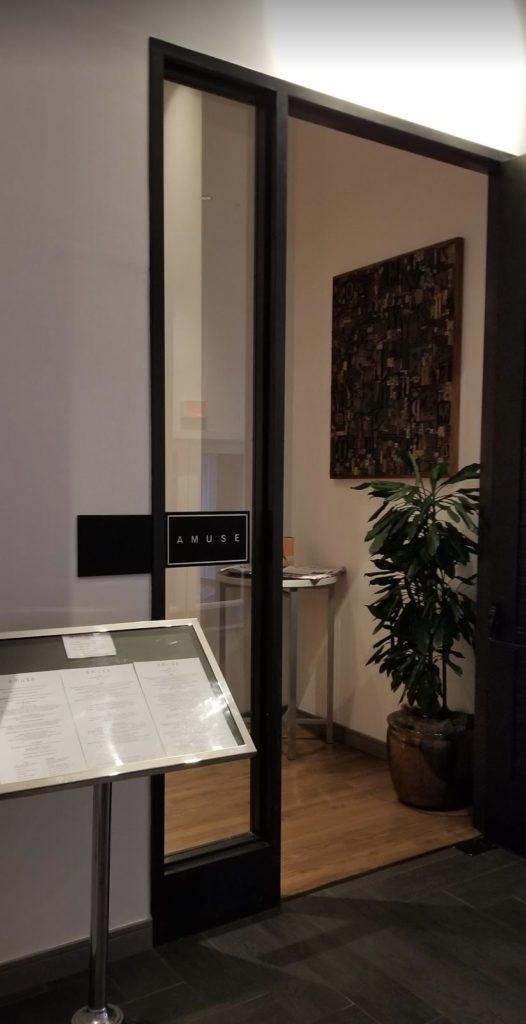 a glass door with a sign and a table in front of it