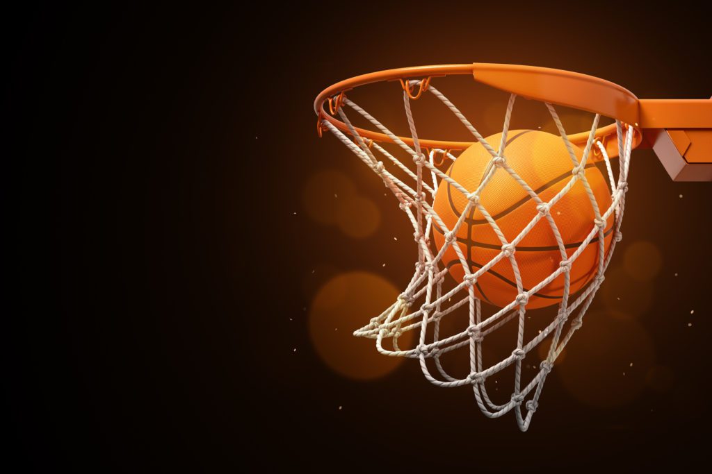 A basketball is going through a hoop.