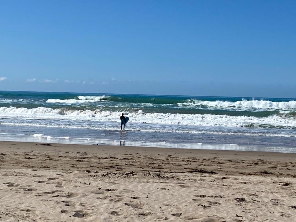 a person holding a surfboard on a beach