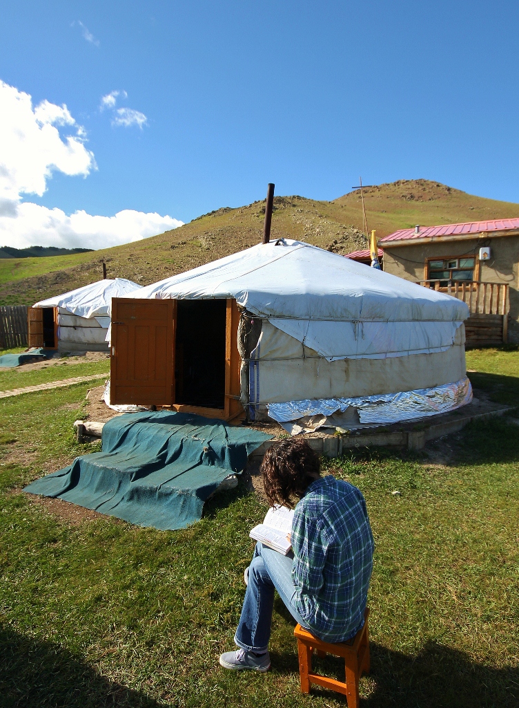 a person sitting in front of a yurt