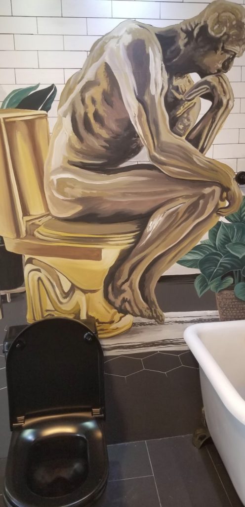 a mural of a woman sitting on a toilet