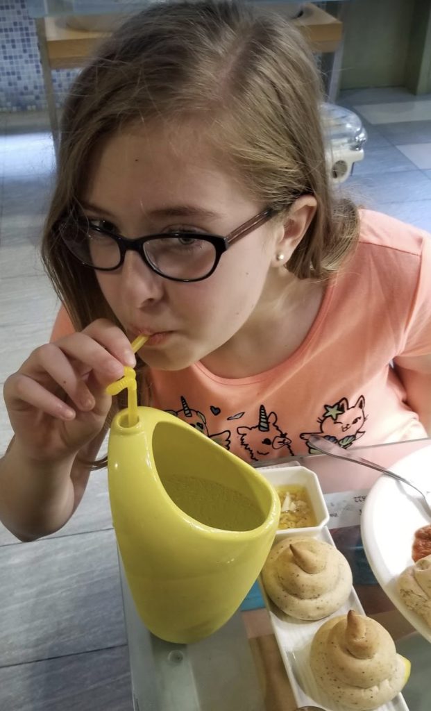 a girl drinking from a yellow tube