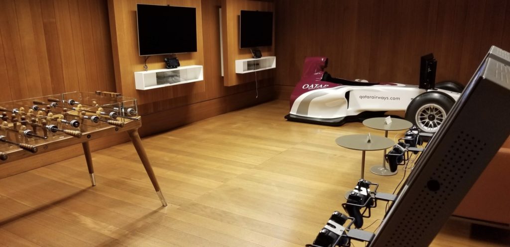 a room with a race car and tvs
