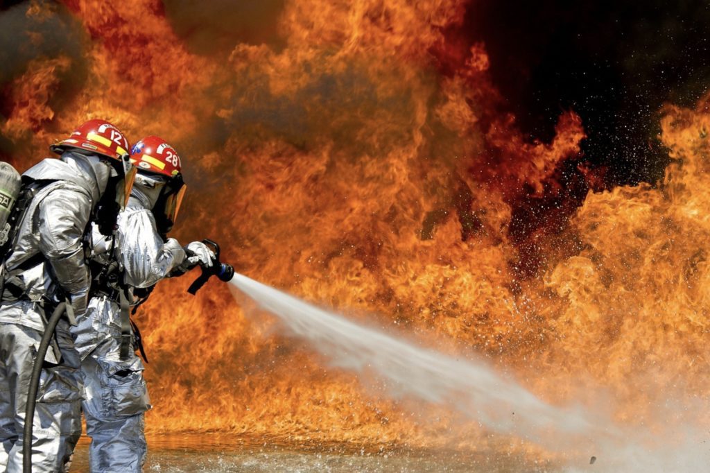 a firefighter spraying water on fire