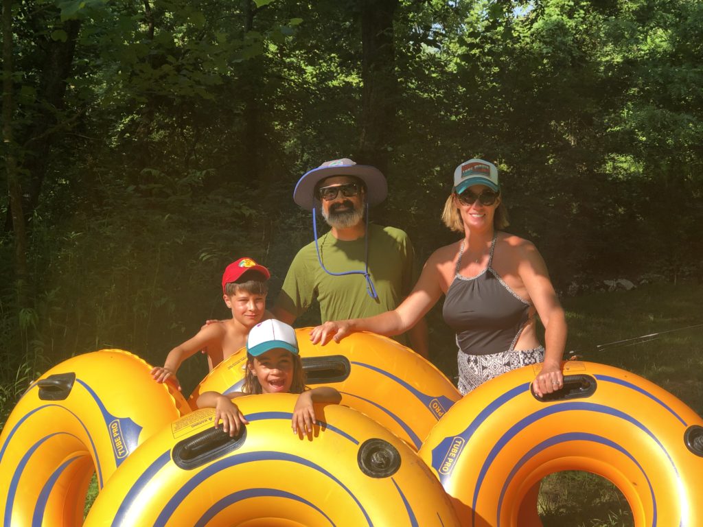 a group of people standing next to yellow inflatable tubes