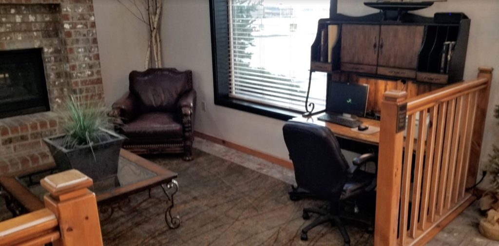 a room with a computer desk and chairs