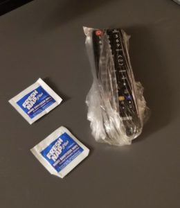 a remote control wrapped in plastic and some small packets