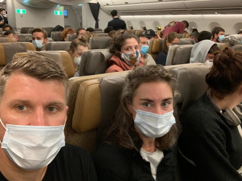 a group of people wearing masks on an airplane