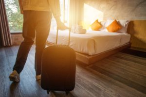 a person with luggage in a hotel room