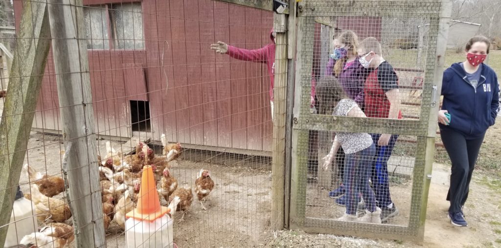 a group of people in a chicken coop