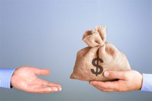 a hand holding a sack of money