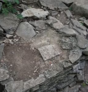 a rock wall with dirt and rocks