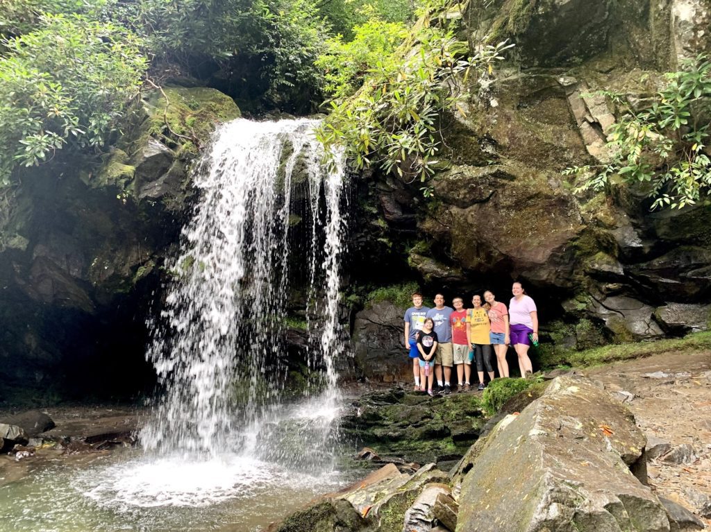 a group of people standing in front of a waterfall