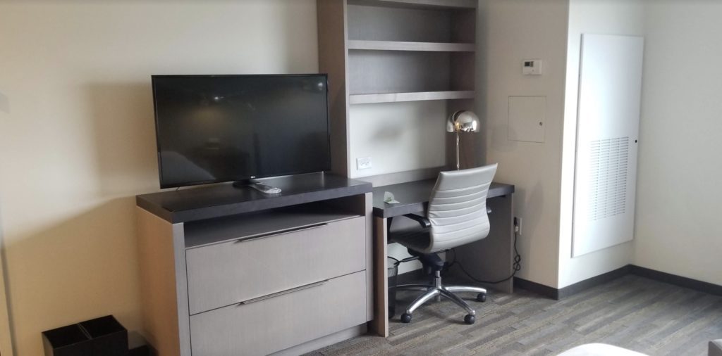 a desk with a chair and a tv