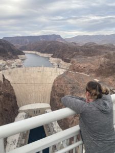 a woman leaning on a railing overlooking a large dam