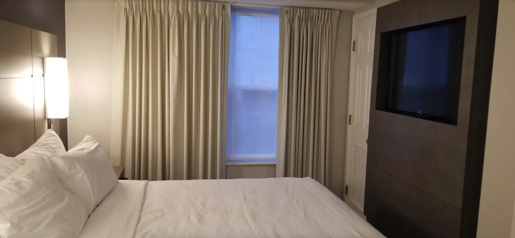 a bed with a white sheet and curtains