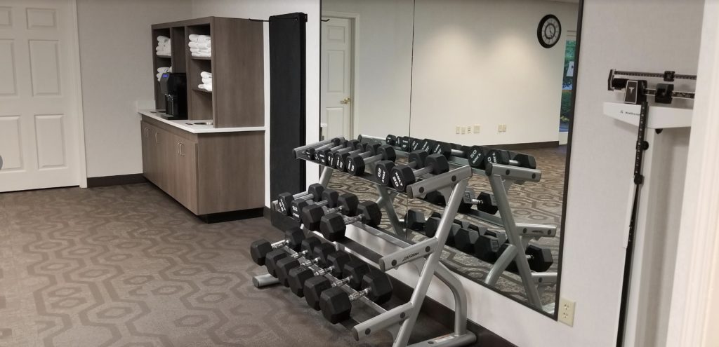 a room with a mirror and dumbbells