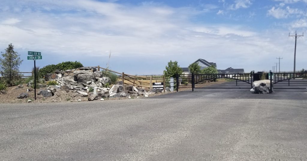 a road with a fence and rocks