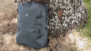 a backpack leaning against a tree