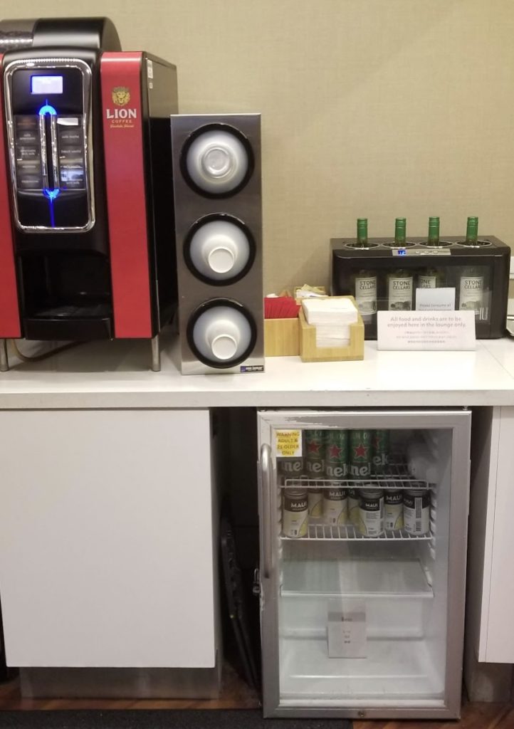 a mini fridge with drinks and a drink dispenser