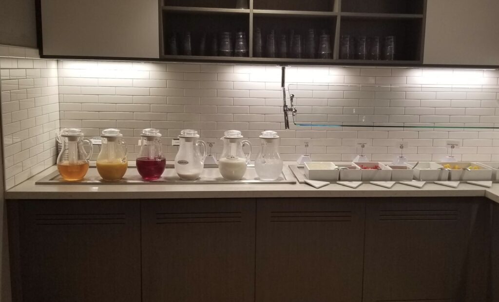 a counter with a group of jugs of liquid and a tray of food