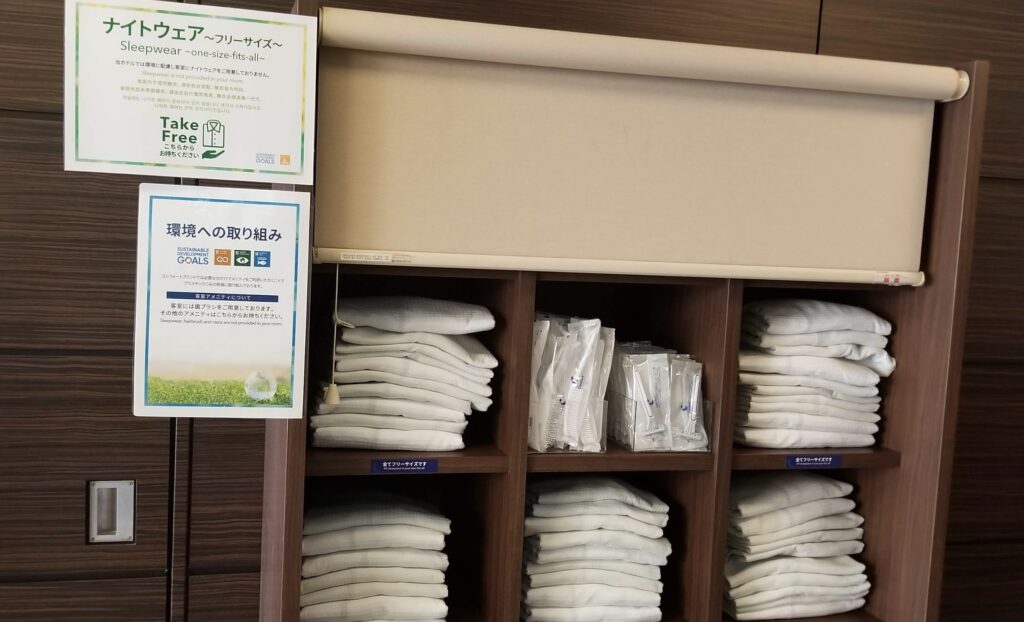 a shelf with white towels and signs
