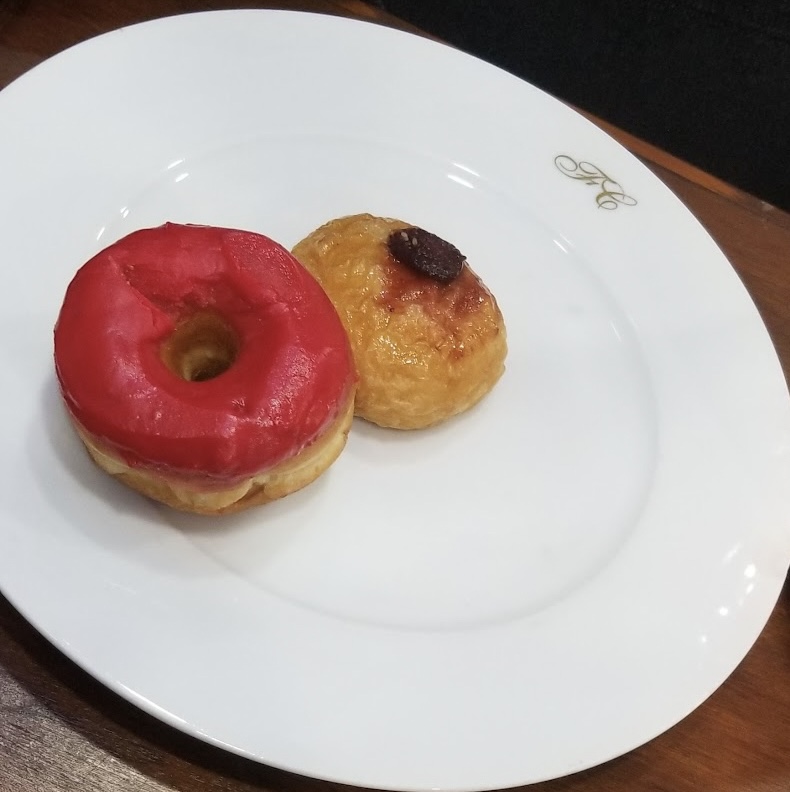 a plate of donuts on a wood table