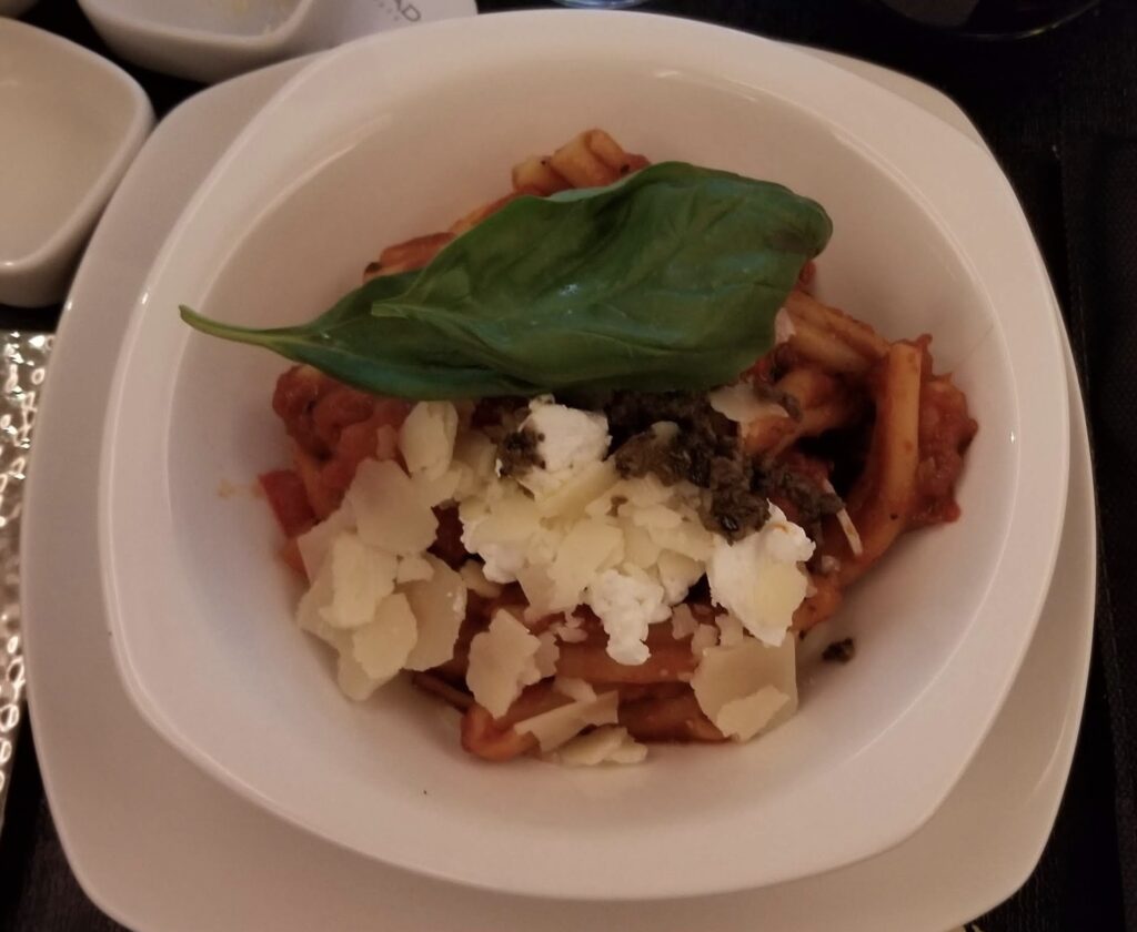 a bowl of pasta with cheese and basil