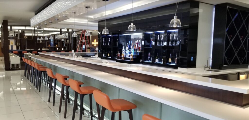 a bar with shelves of liquor and stools