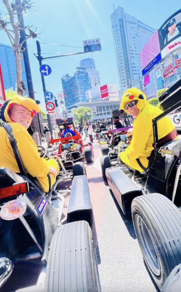 two men in yellow clothing on go karts
