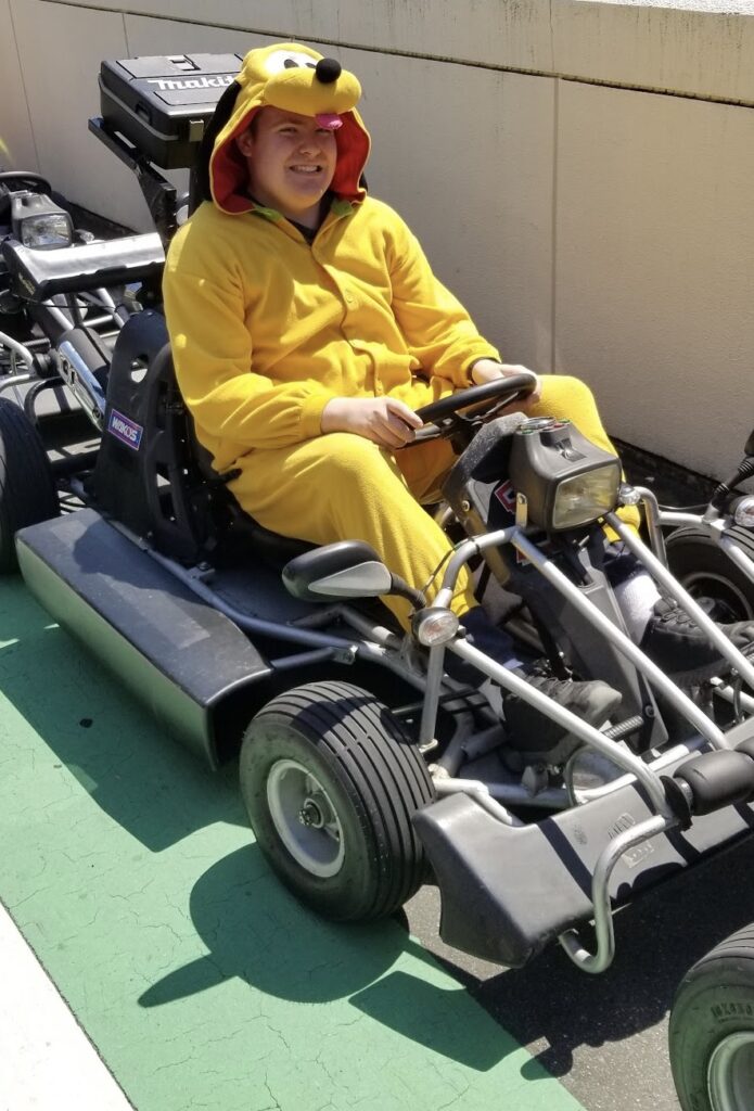 a person in a yellow outfit on a go kart