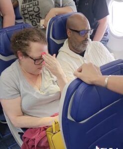 a man and woman sitting in chairs on an airplane