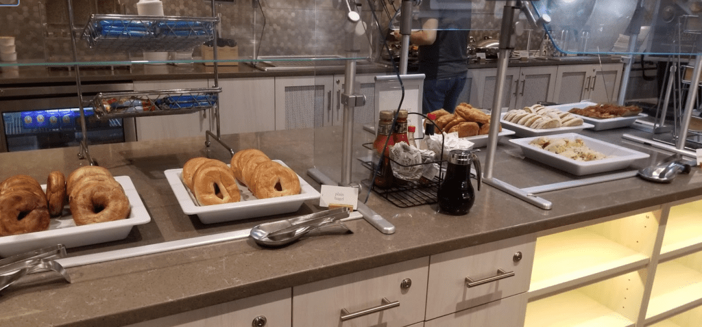 a counter with a tray of bagels and a couple of other bagels