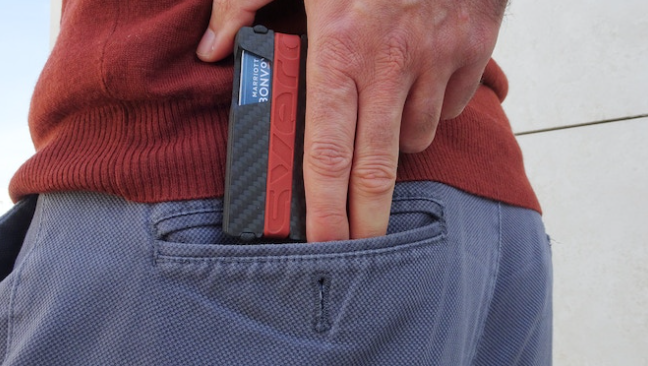 a hand holding a cassette tape in a pocket