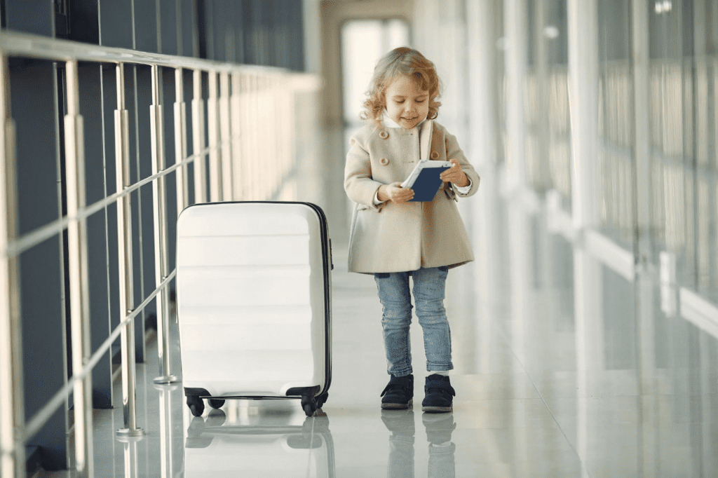 a girl standing in a hallway with a suitcase