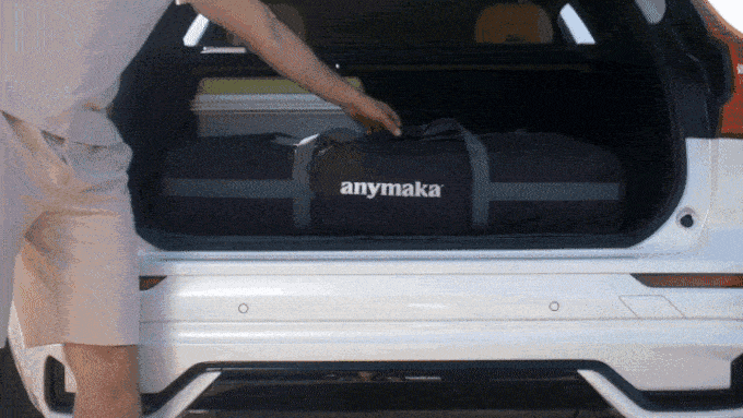 a person putting a luggage in the back of a car