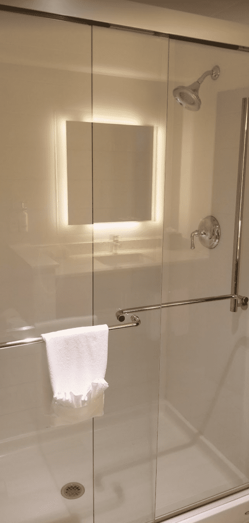 a glass shower door with a white towel on it