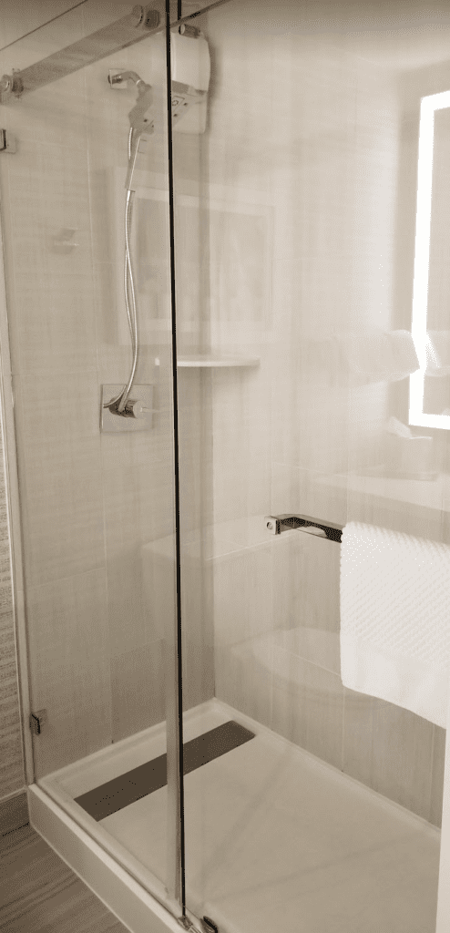 a glass shower with a towel on a rack