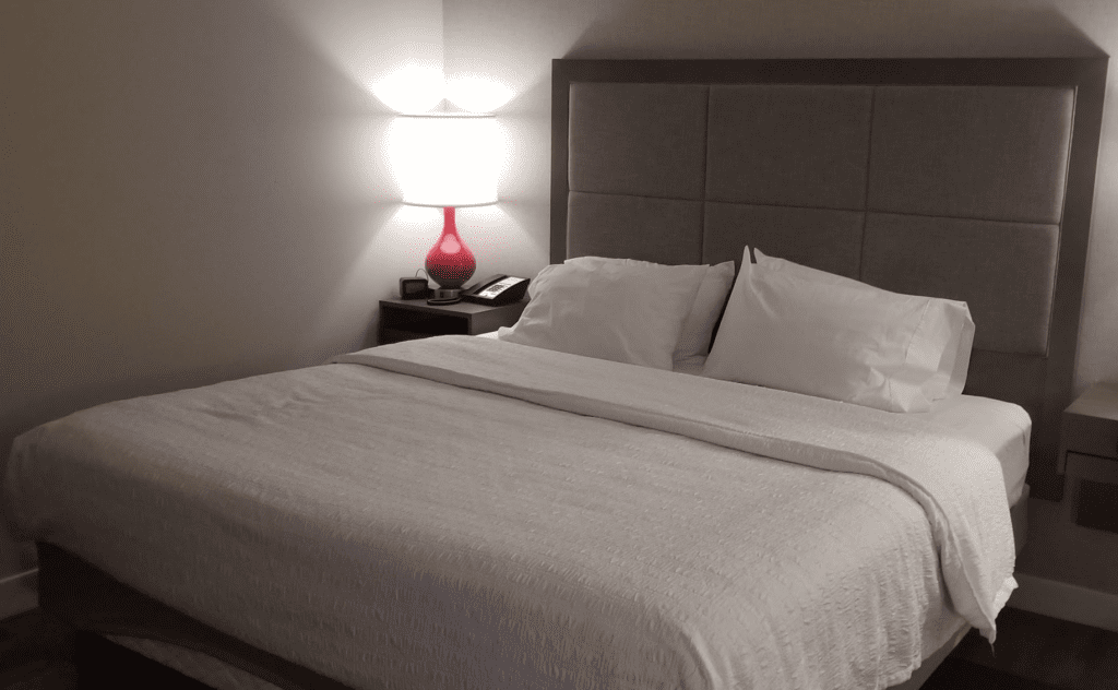 a bed with a lamp on the side