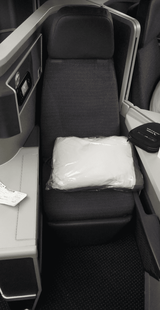 a white pillow in a plastic bag on a seat